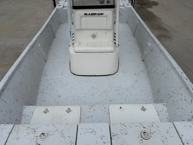 Slide: The Image of 2012 Blazer 2400 boat interior with white seating and textured flooring. - 14