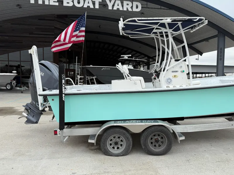 Slide: The Image of 2012 Blazer 2400 boat on trailer with American flag at The Boat Yard. - 9