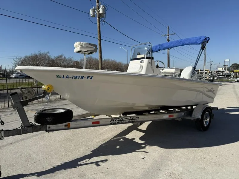 Slide: The Image of 2011 NauticStar 190R RG boat on trailer with blue canopy, parked outdoors. - 10