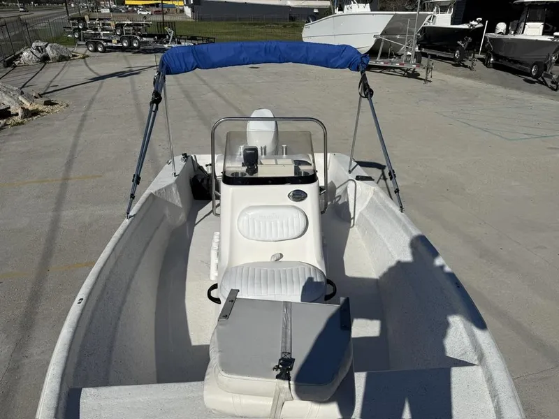 Slide: The Image of 2011 NauticStar 190R RG boat with blue canopy, parked on concrete surface. - 13