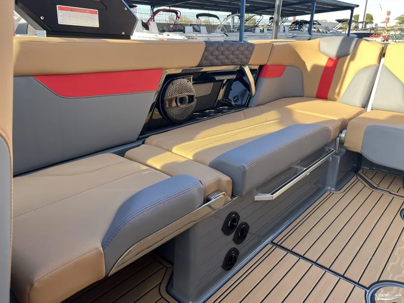 Slide: The Image of 2025 MasterCraft XT25 interior with tan and gray seating, featuring a built-in speaker system. - 12