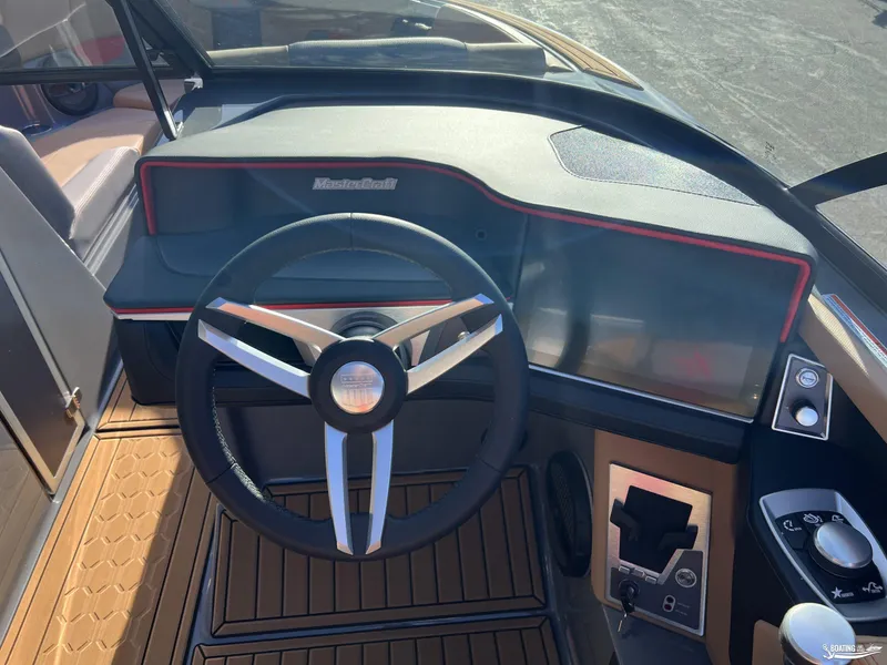 Slide: The Image of 2025 MasterCraft XT25 boat dashboard with steering wheel and control panel. - 7