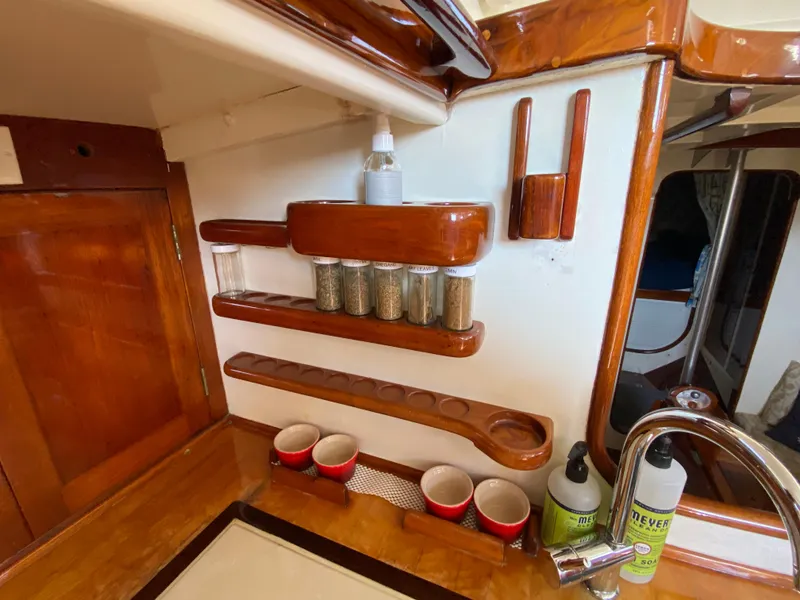 Slide: The Image of 1962 Cheoy Lee Custom yacht kitchen with wooden spice rack and red mugs. - 16