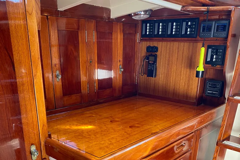 Slide: The Image of 1962 Cheoy Lee Custom yacht interior with polished wood cabinetry and control panels. - 21