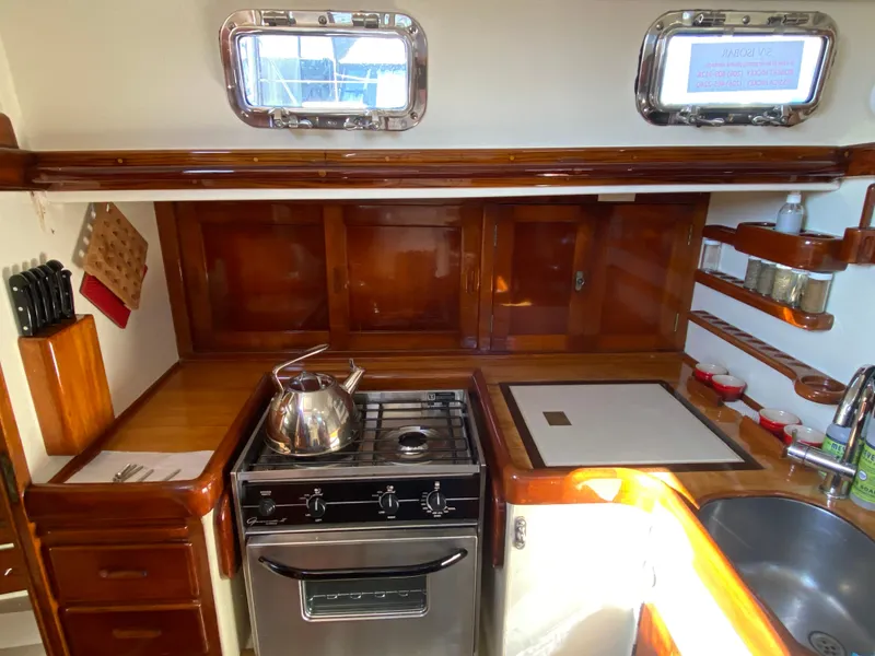 Slide: The Image of Vintage 1962 Cheoy Lee Custom yacht kitchen with stove, sink, and wooden cabinetry. - 25