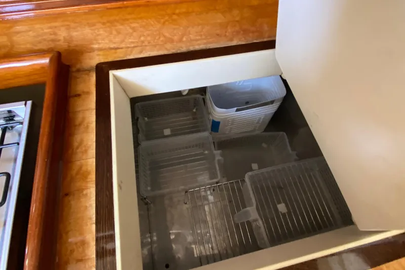 Slide: The Image of Storage compartment with plastic containers on a 1962 Cheoy Lee Custom boat. - 27