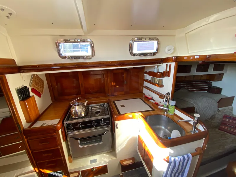 Slide: The Image of 1962 Cheoy Lee Custom yacht kitchen with stove, sink, and wooden cabinetry. - 3