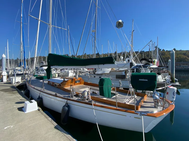 Slide: The Image of 1962 Cheoy Lee Custom sailboat docked at marina under clear blue sky. - 32