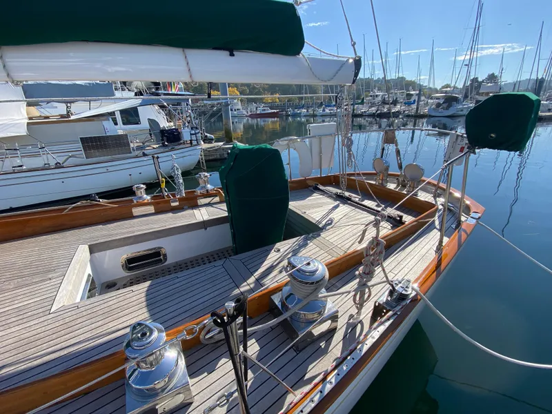 Slide: The Image of 1962 Cheoy Lee Custom yacht docked in a marina, showcasing elegant wooden deck and rigging. - 39