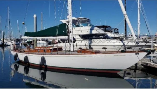 Slide: The Image of 1962 Cheoy Lee Custom sailboat docked in a marina, featuring classic design and green sail cover. - 47