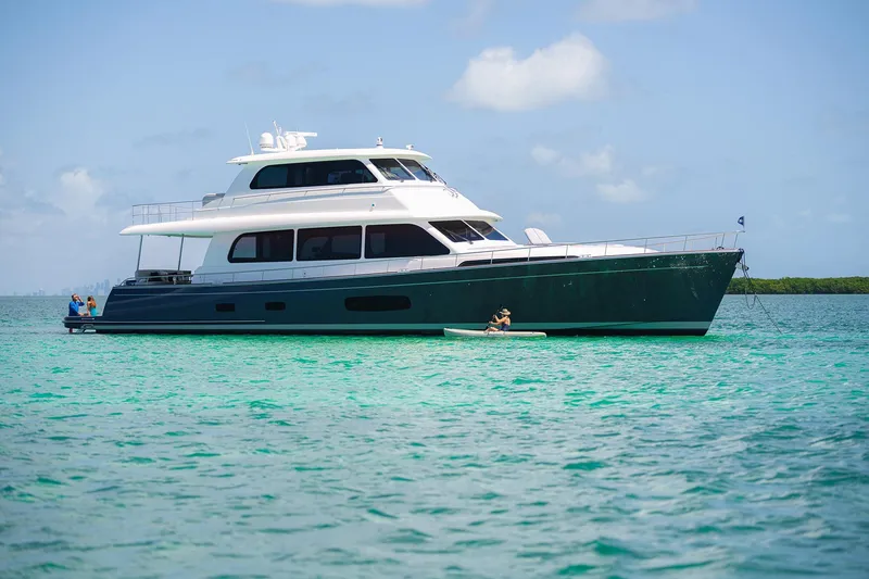 Slide: The Image of 2026 Grand Banks GB 85 yacht on turquoise water under blue sky. - 0