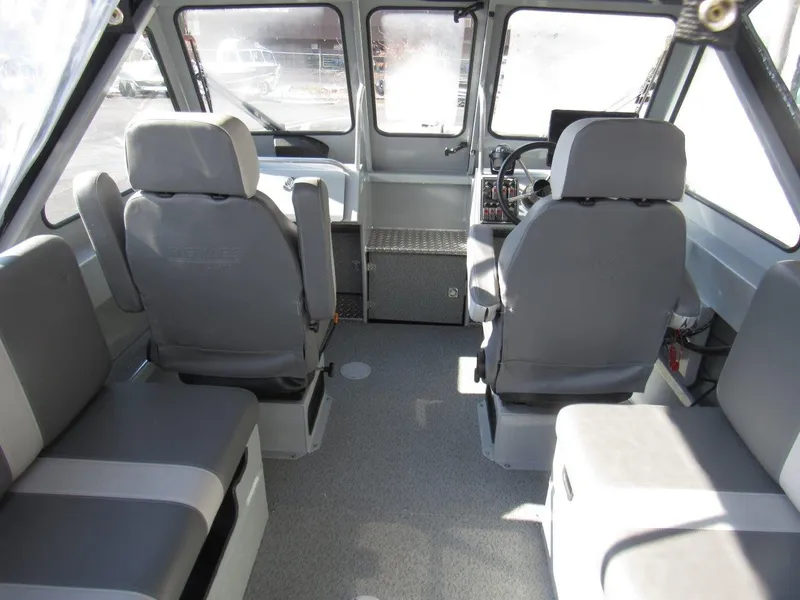 Slide: The Image of Interior of 2023 Hewescraft 210 Sea Runner ET boat, featuring gray seating and dashboard. - 17