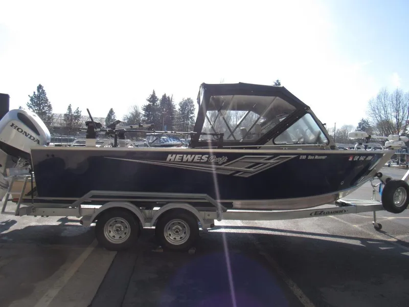 Slide: The Image of 2023 Hewescraft 210 Sea Runner ET boat on trailer, side view, outdoors. - 6