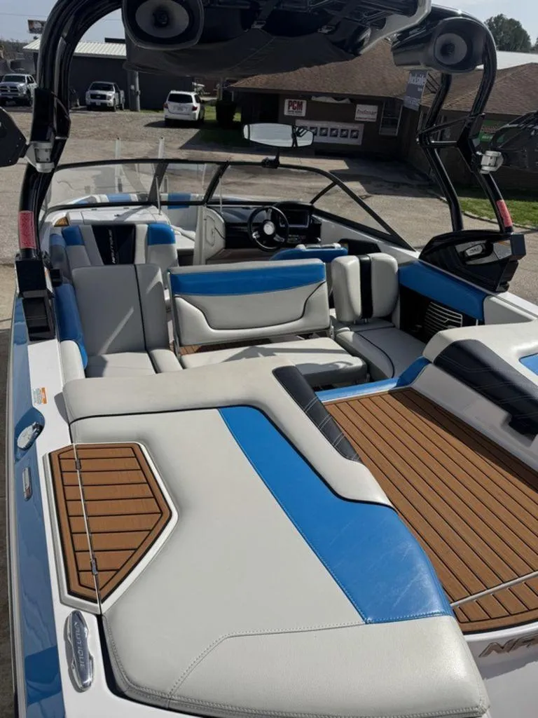 Slide: The Image of 2015 Nautique G21 boat interior with blue and white seating, teak flooring, and modern dashboard. - 7