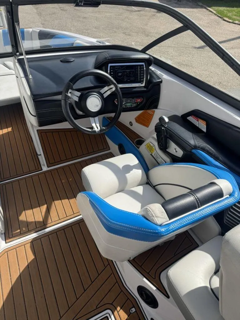 Slide: The Image of 2015 Nautique G21 boat interior with steering wheel and dashboard, featuring wood-style flooring. - 8