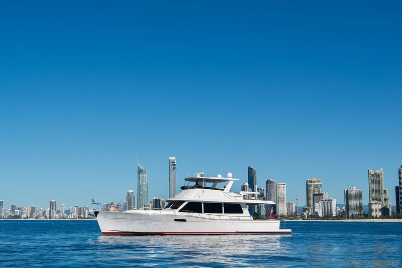 Slide: The Image of 2026 Grand Banks GB 60 yacht cruising near a city skyline on a clear day. - 9