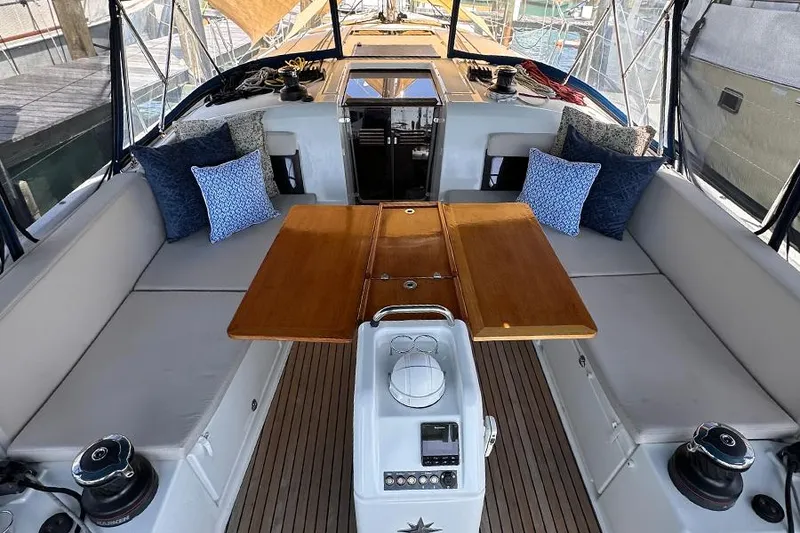 Slide: The Image of 2019 Jeanneau Sun Odyssey 490 cockpit with cushioned seating and wooden table. - 12