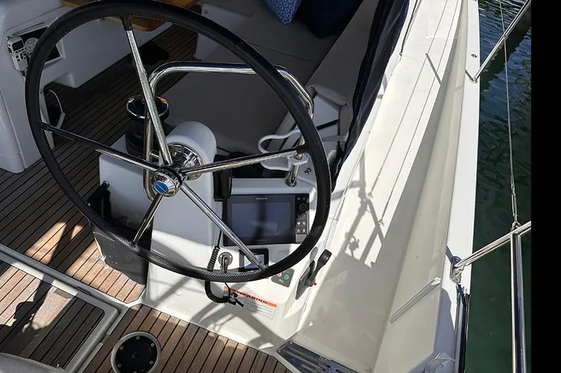 Slide: The Image of Steering wheel of 2019 Jeanneau Sun Odyssey 490 sailboat, featuring modern navigation equipment. - 16