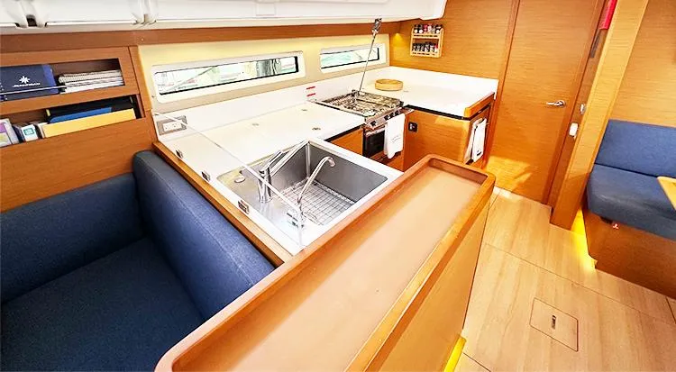 Slide: The Image of Interior of 2019 Jeanneau Sun Odyssey 490 yacht with modern kitchen and seating area. - 23