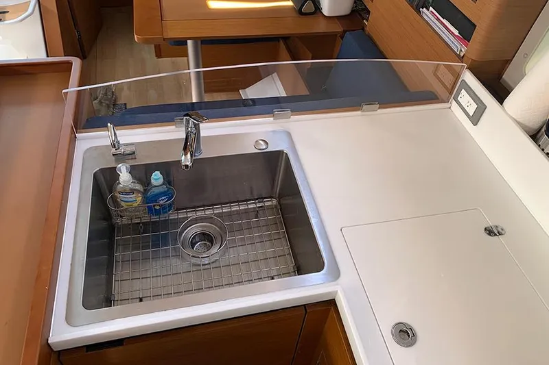 Slide: The Image of Modern kitchen sink in 2019 Jeanneau Sun Odyssey 490 yacht, featuring sleek design and functionality. - 31
