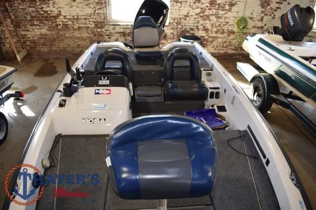 Slide: The Image of 1997 ProCraft 180 boat interior with blue seats in a brick-walled garage. - 12