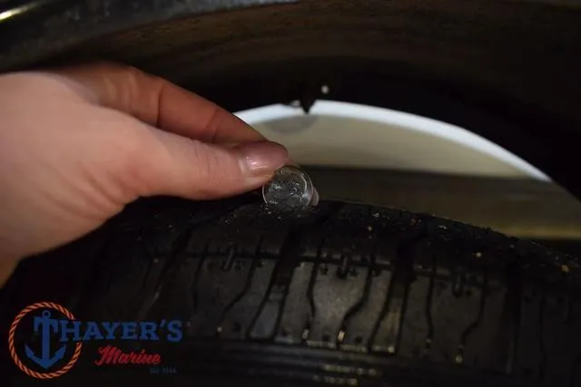 Slide: The Image of Hand checking tire tread depth on ProCraft 180, 1997 model, at Thayer's Marine. - 32