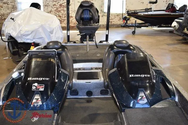 Slide: The Image of 2011 Ranger Z520C boat interior with dual seats and console in a showroom. - 14