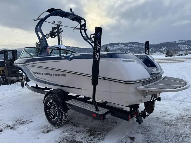 Slide: The Image of 2015 Nautique 200 boat on trailer in snowy landscape, featuring sleek design and wakeboard tower. - 11