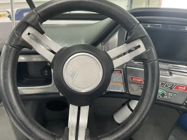 Slide: The Image of Steering wheel of a 2015 Nautique 200 boat with dashboard controls. - 13