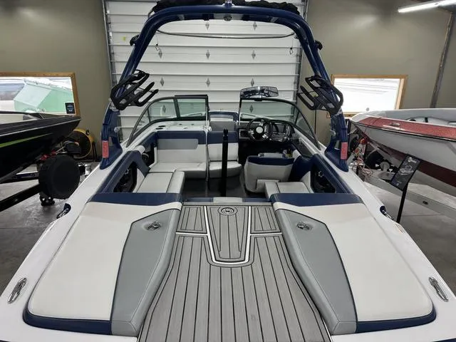 Slide: The Image of 2015 Nautique 200 boat interior with seating and dashboard in a garage setting. - 5