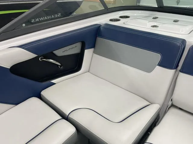 Slide: The Image of Interior seating of a 2015 Nautique 200 boat, featuring blue and white upholstery. - 6