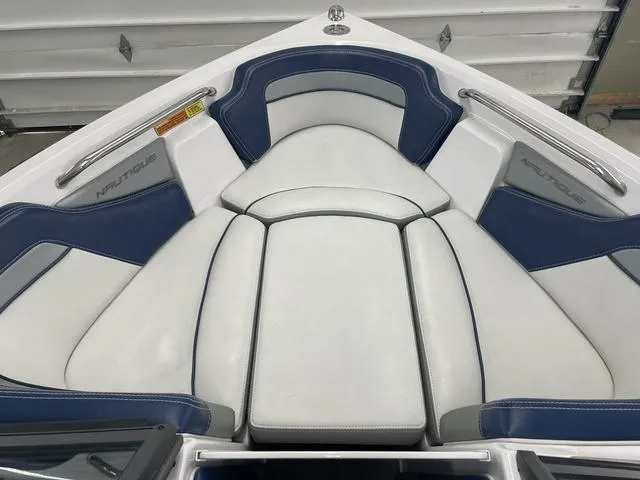 Slide: The Image of 2015 Nautique 200 boat interior with white and blue cushioned seating. - 7