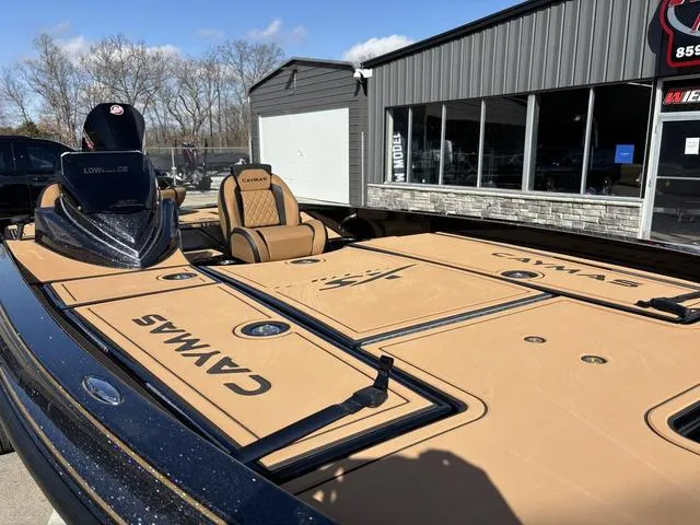 Slide: The Image of 2025 Caymas XS 21 Pro boat with tan deck, parked outside a showroom. - 11