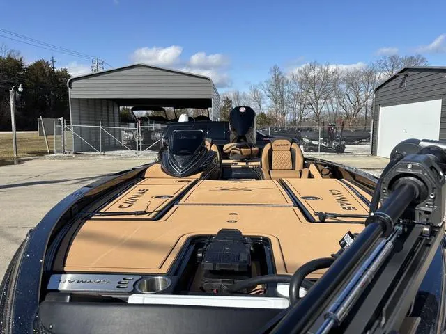 Slide: The Image of 2025 Caymas XS 21 Pro boat with tan interior, parked outdoors under a clear sky. - 13