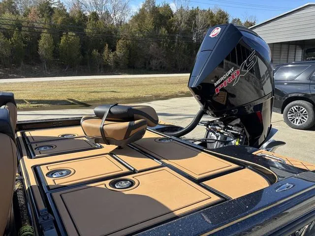 Slide: The Image of 2025 Caymas XS 21 Pro boat with Mercury engine, tan deck, and outdoor setting. - 16