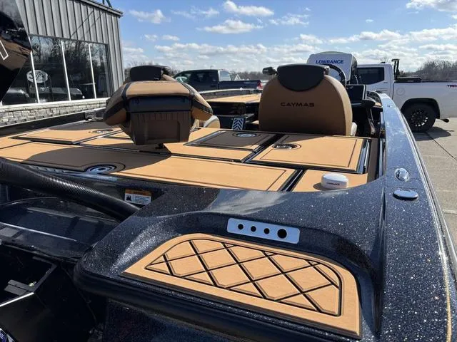 Slide: The Image of 2025 Caymas XS 21 Pro boat with tan seating and deck, parked outdoors. - 4