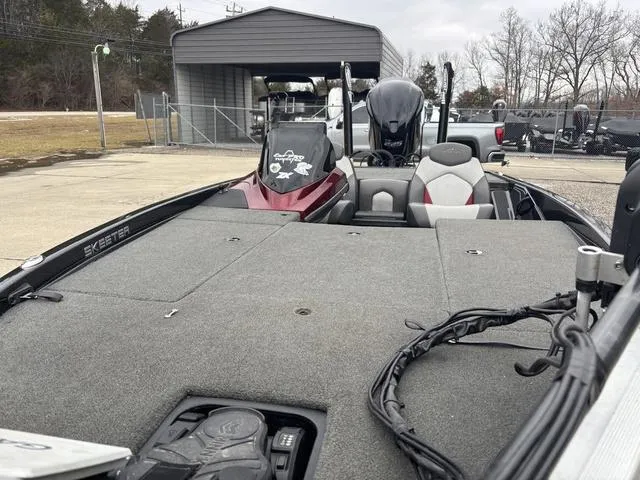 Slide: The Image of 2015 Skeeter ZX 225 bass boat with spacious deck and seating, parked outdoors. - 12