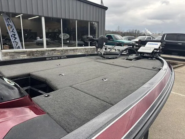 Slide: The Image of 2015 Skeeter ZX 225 bass boat with spacious deck, parked outside showroom. - 8