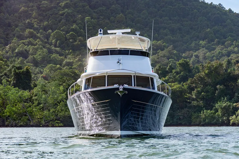 Slide: The Image of 2026 Grand Banks GB 54 yacht on serene water with lush green backdrop. - 2