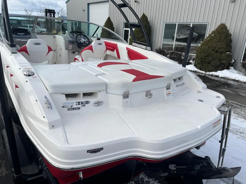 Slide: The Image of 2016 Chaparral 21 H2O boat with red and white interior, parked outdoors. - 3