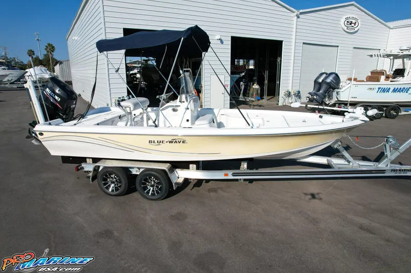 Slide: The Image of 2011 Blue Wave 2200 Pure Bay boat on trailer, parked outside a marine facility. - 11