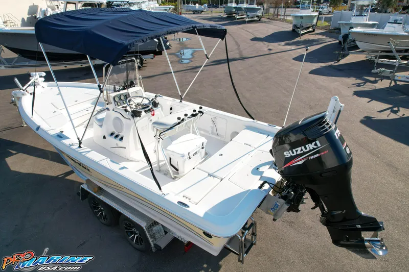 Slide: The Image of 2011 Blue Wave 2200 Pure Bay boat with Suzuki outboard motor, parked on a trailer. - 15