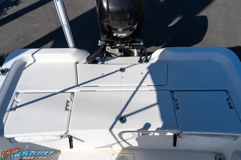 Slide: The Image of 2011 Blue Wave 2200 Pure Bay boat deck with motor, featuring storage compartments. - 24