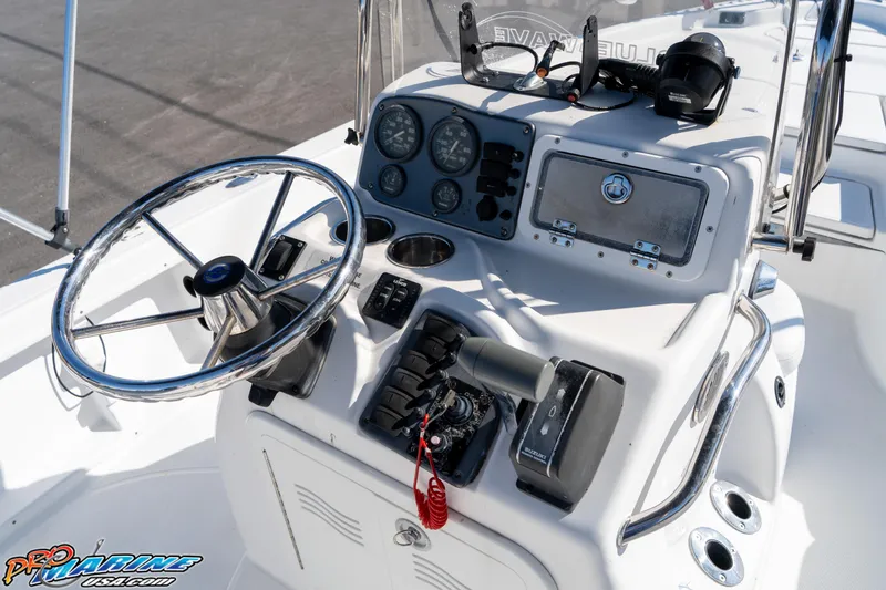 Slide: The Image of 2011 Blue Wave 2200 Pure Bay boat console with steering wheel and controls. - 28
