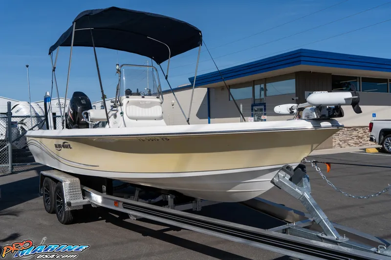 Slide: The Image of 2011 Blue Wave 2200 Pure Bay boat on trailer, parked outside a building. - 6