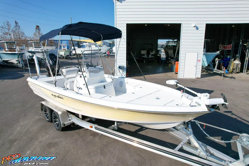 Slide: The Image of 2011 Blue Wave 2200 Pure Bay boat on trailer, parked outside a building. - 8