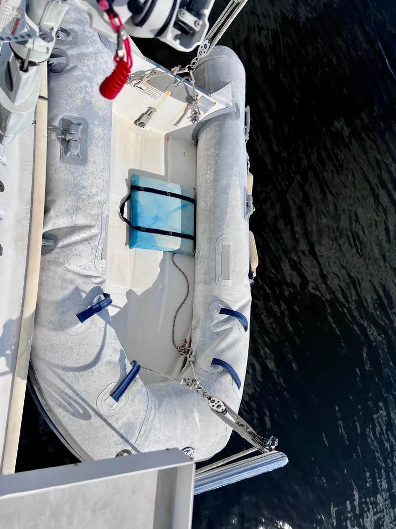 Slide: The Image of Inflatable dinghy attached to a 1994 PDQ 32 Classic boat on water. - 13