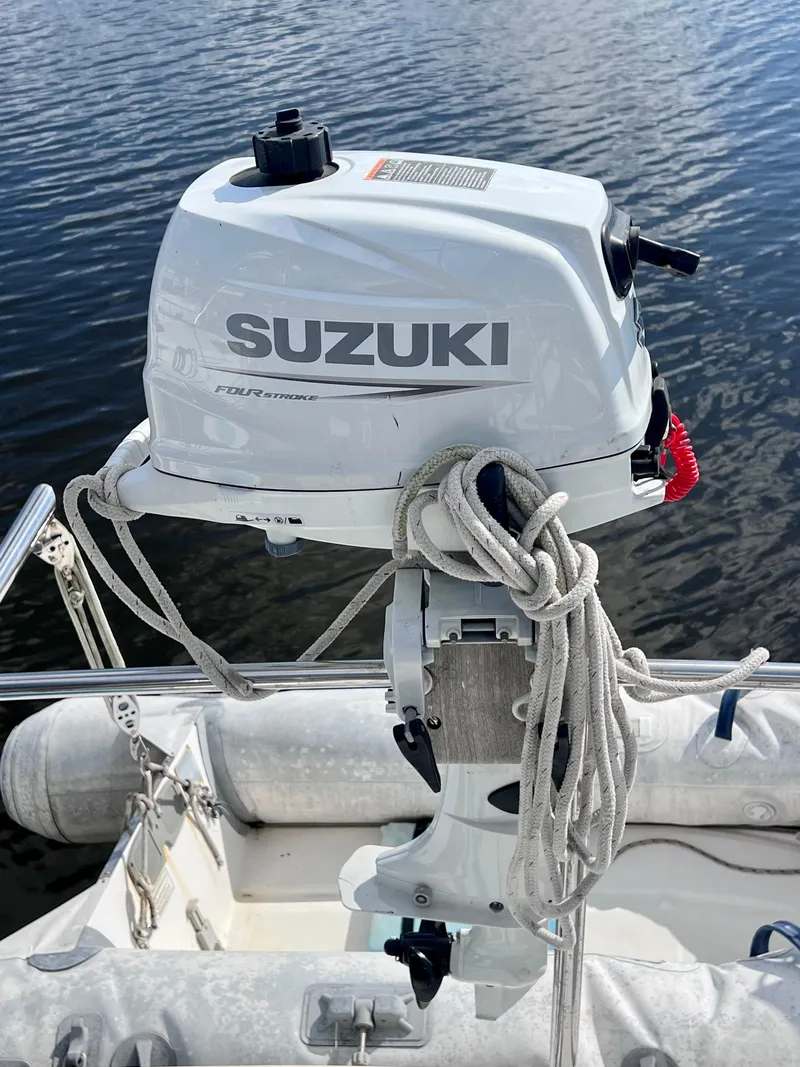 Slide: The Image of Suzuki outboard motor on a 1994 PDQ 32 Classic boat, docked by the water. - 14
