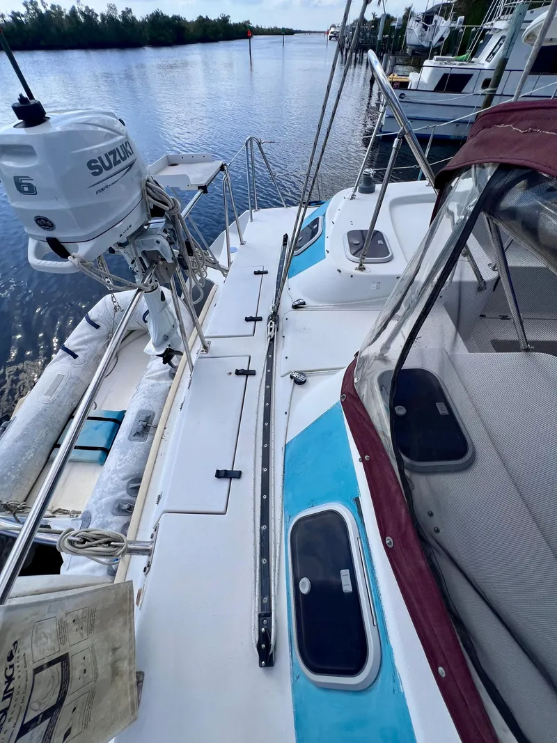 Slide: The Image of 1994 PDQ 32 Classic boat docked, featuring a Suzuki outboard motor and spacious deck. - 16