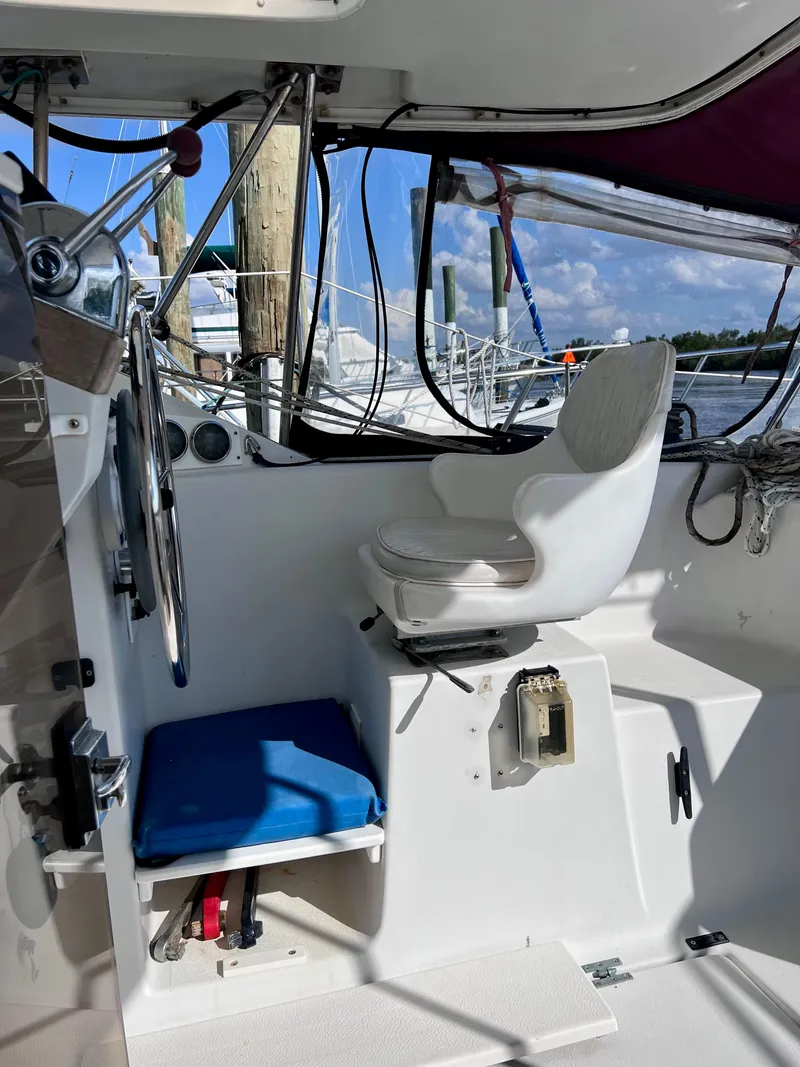 Slide: The Image of 1994 PDQ 32 Classic boat cockpit with steering wheel and white captain's chair. - 20